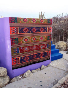 Handwoven Oaxaca Amado Wool Rug, made of natural wool, with greens reds and purples woven in a tribal pattern